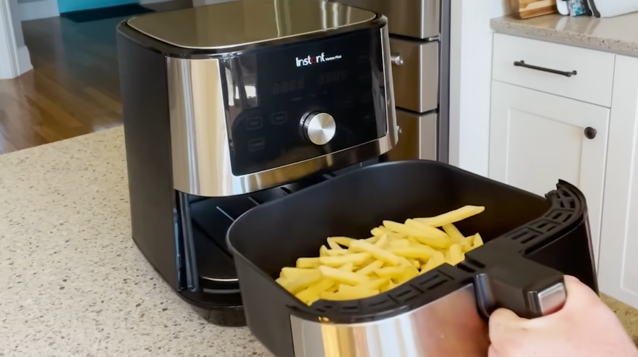 person puts the cut potato in the air fryer on the kitchen