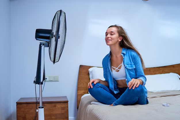 Young pretty woman sits on the bed in the bedroom in and enjoys the fresh air