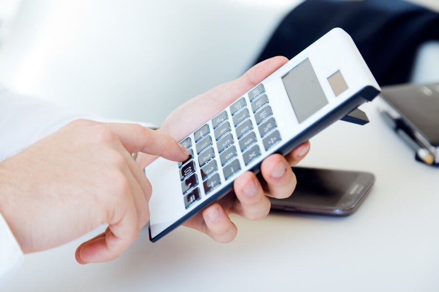 Hand using a calculator and pressing buttons